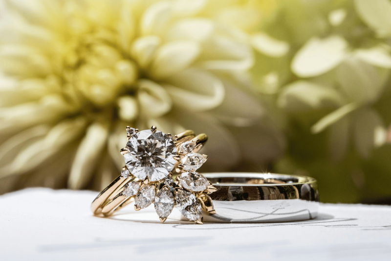 Anelli in oro con diamanti su sfondo floreale elegante