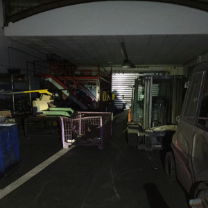 Magazzino industriale con muletto, gabbia metallica e scala rossa. Scena del tentato furto sventato da Sicuritalia a Copparo.